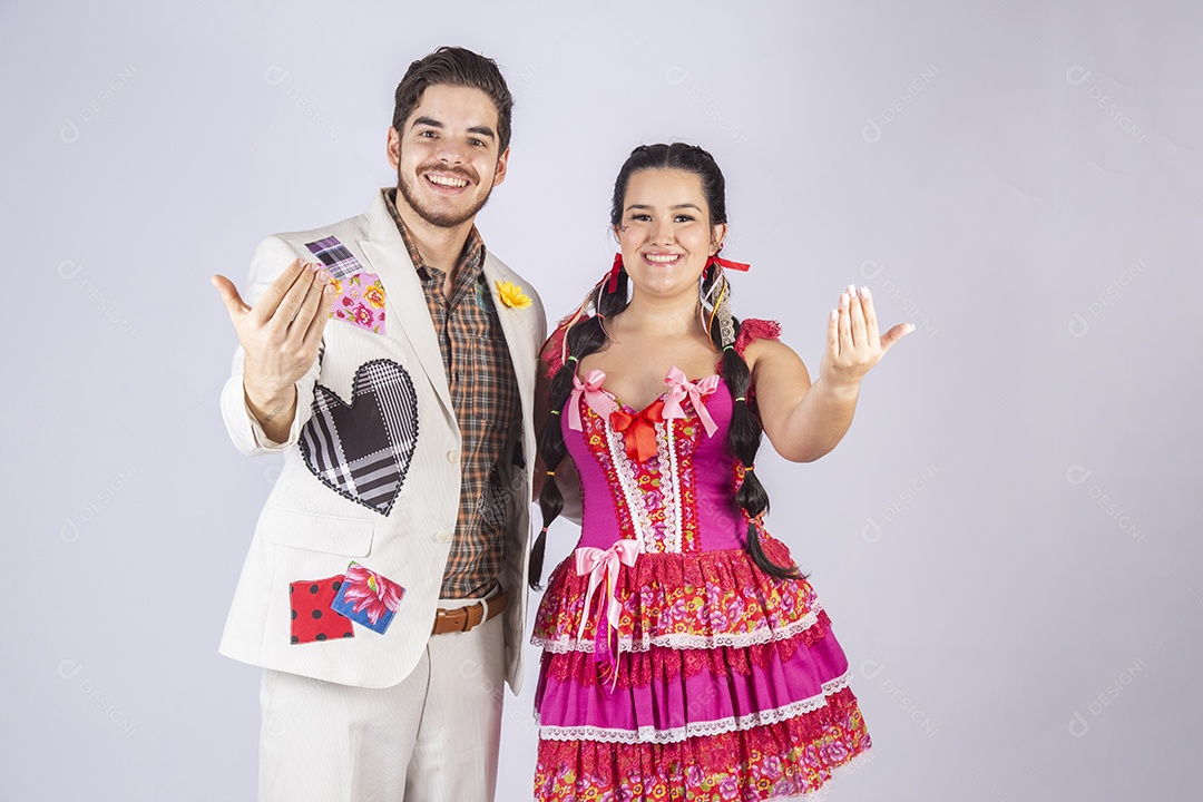 Casal a caráter para festa de São João abraçados com gesto de chamar