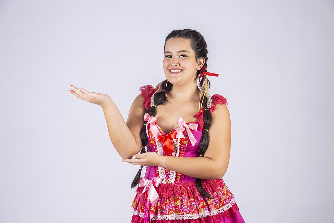 Garota bonita com trajes para festa junina com mãos para o lado