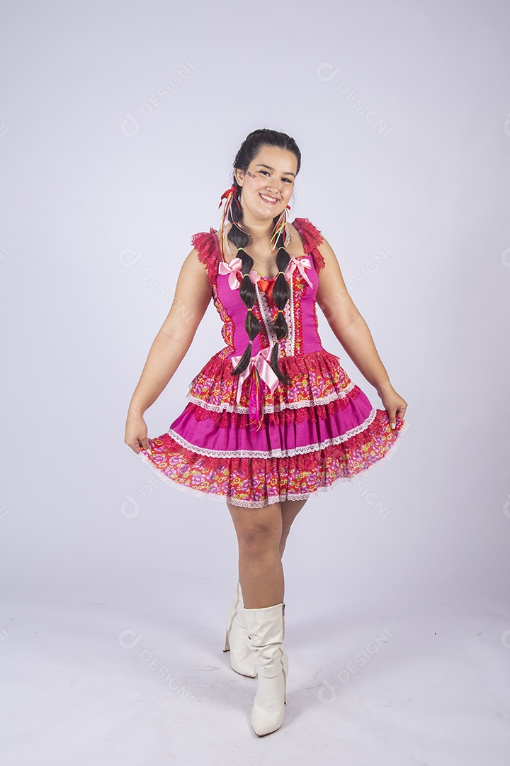 Jovem moça linda trajada para festa junina pegando no vestido