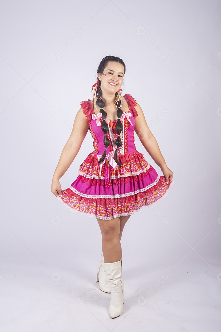 Jovem moça linda trajada para festa junina pegando no vestido