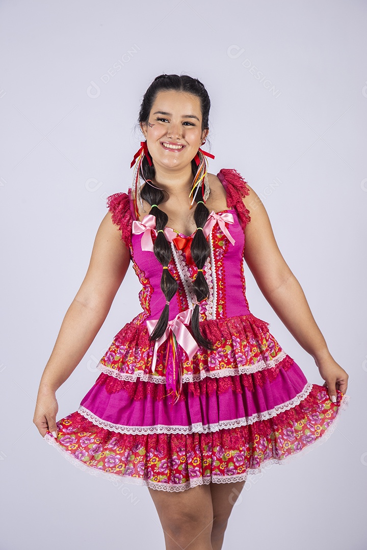 Jovem moça trajada para festa junina com mãos no vestido
