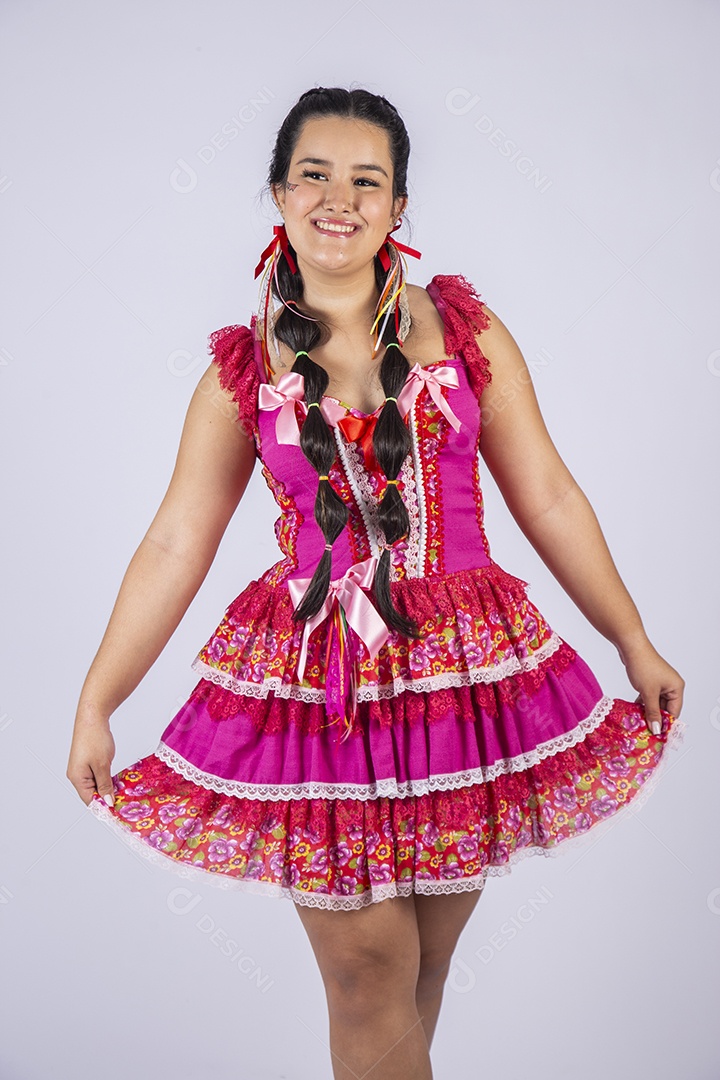 Jovem moça linda trajada para festa junina pegando no vestido