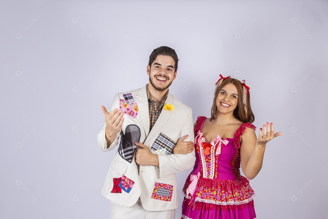 Casal de jovem quadrilheiros trajados para festa junina chamando