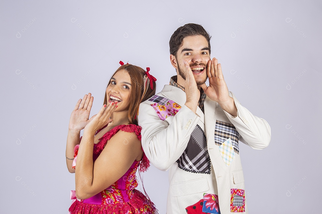 Casal de jovem quadrilheiros trajados para festa junina gritando