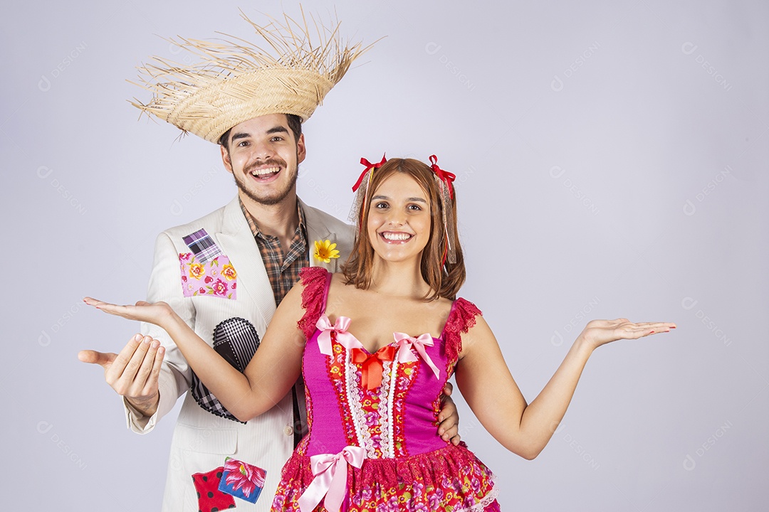 Casal de quadrilheiros juninos de mãos para cima