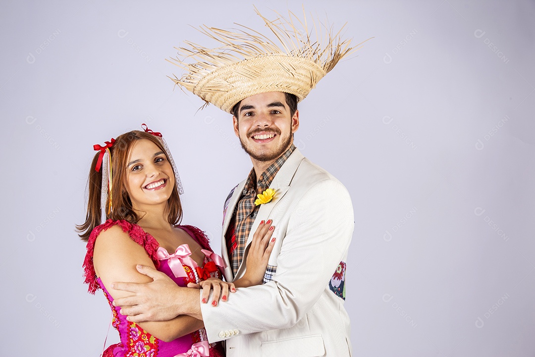 Casal de quadrilheiros junino de braços dados e sorrindo