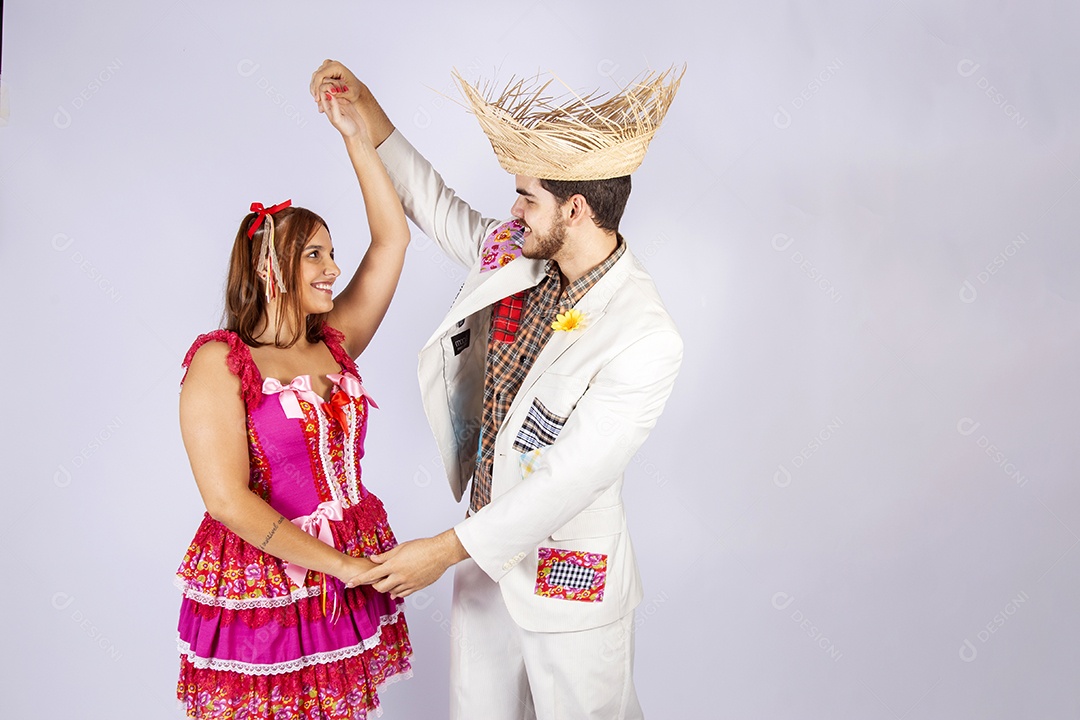 Casal trajado para festa junina de mãos dadas