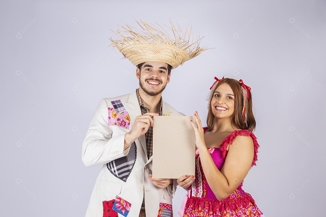 Casal a caráter para festa de São João segurando plaquinha