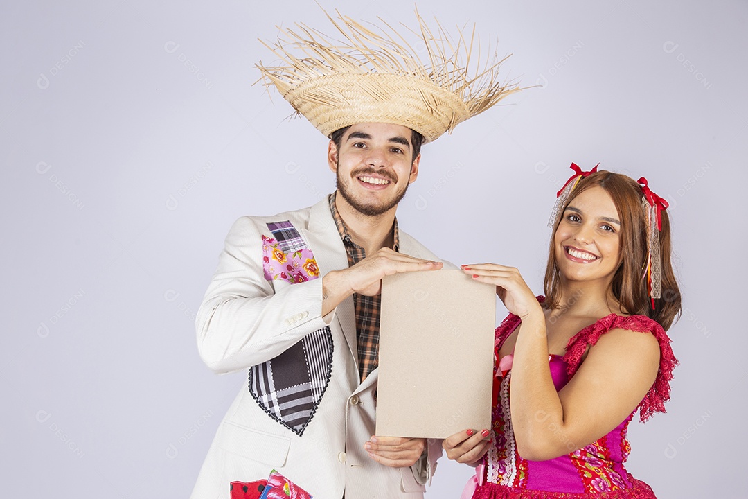 Casal de jovem quadrilheiros trajados para festa junina com plaquinha