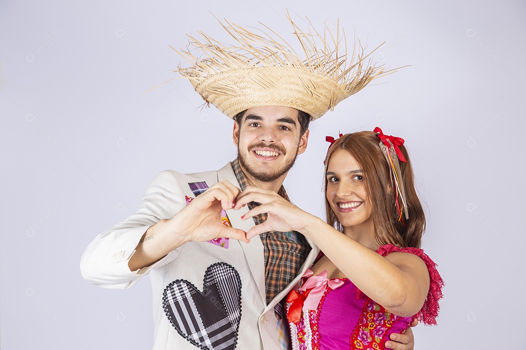Casal a caráter para festa de São João fazendo coração nas mãos