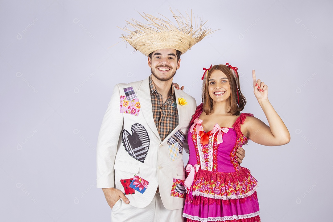 Casal de jovem quadrilheiros trajados para festa junina apontando dedo