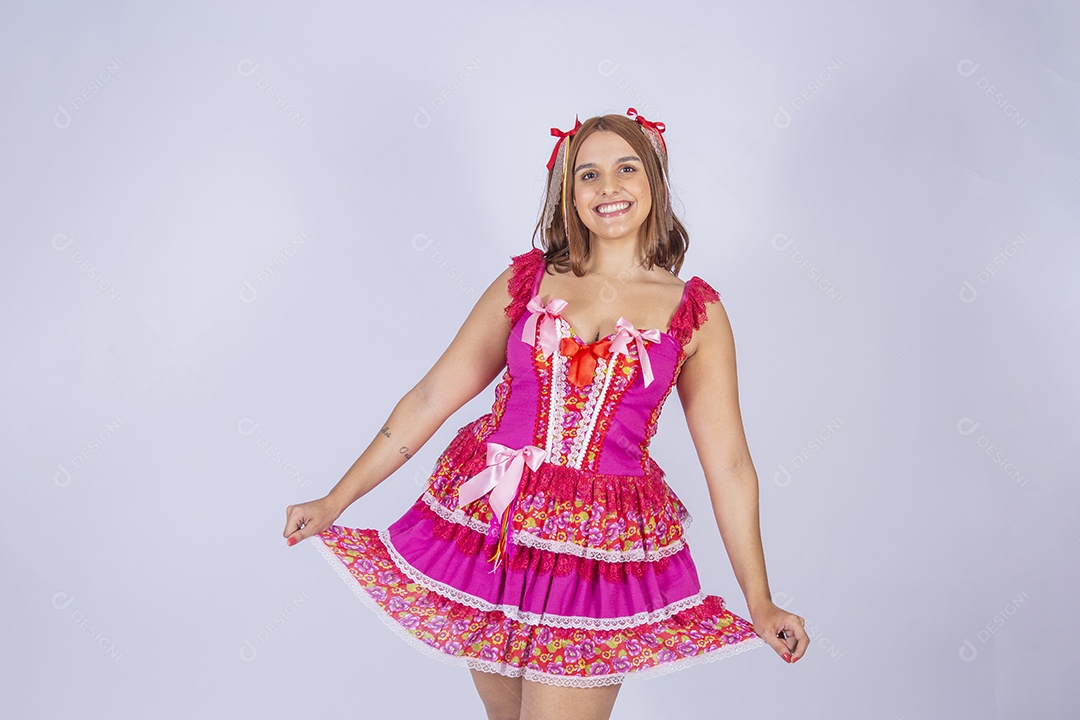 Jovem quadrilheira sorrindo e com trajes para festa junina com mão no vestido