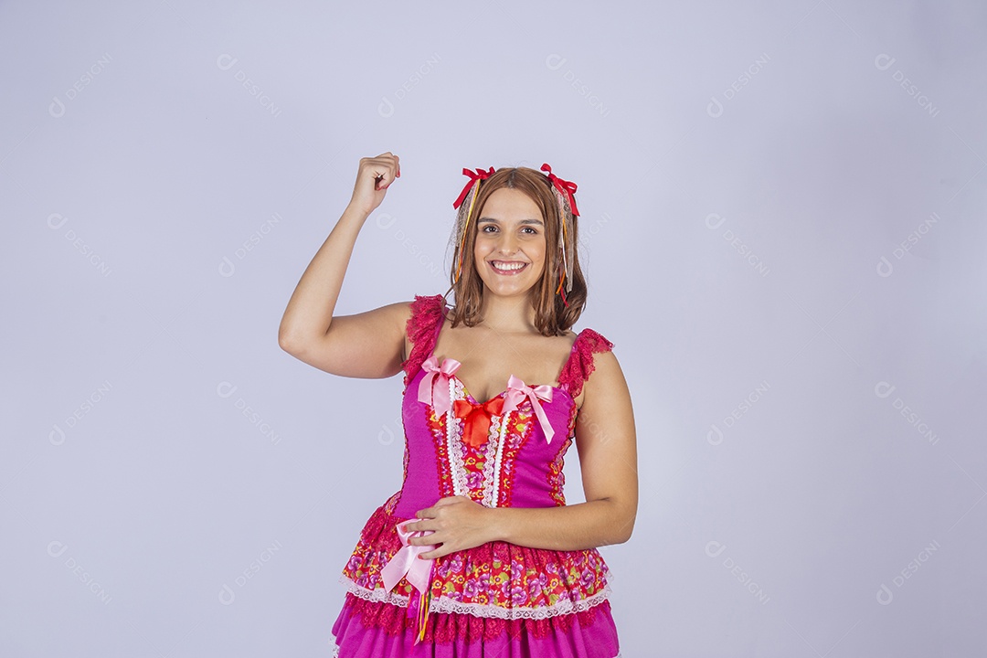 Jovem quadrilheira sorrindo e com trajes para festa junina dançando