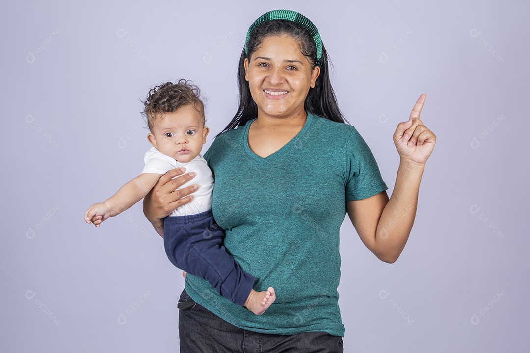 Mãe dedicada e carinhosa segurando seu bebê feliz apontando pra cima