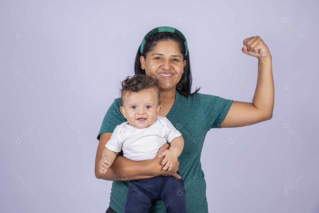 Mãe feliz com seu bebê no colo com gesto de força