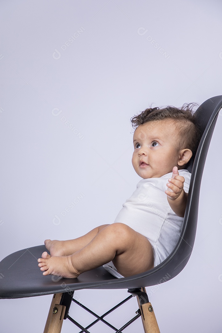 Bebê lindo sentado na cadeira sorrindo