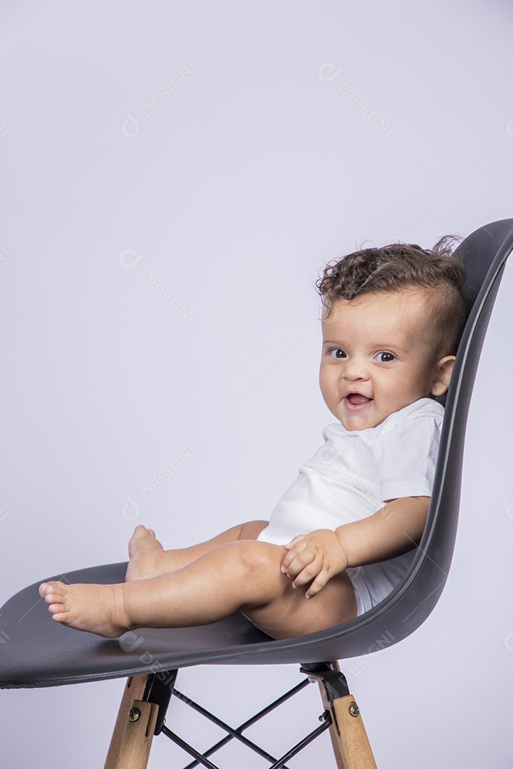 Bebê lindo sentado na cadeira sorrindo