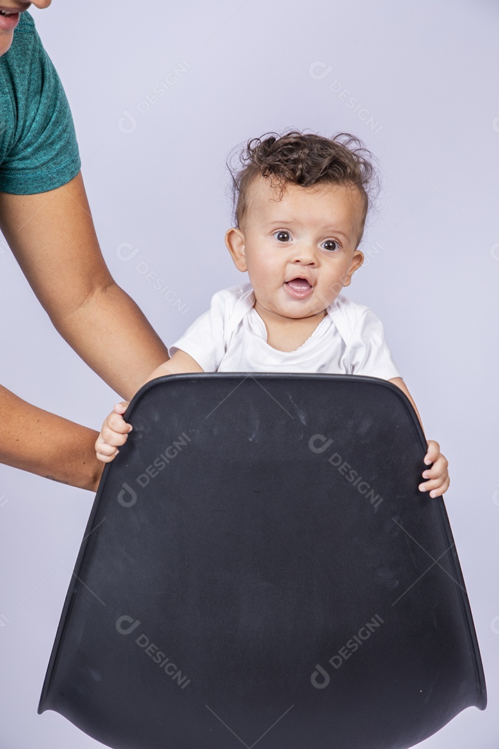 Bebê fofo em pé na cadeira