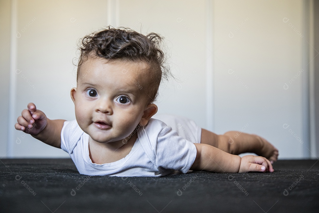 Um bebê fofo deitado na cama