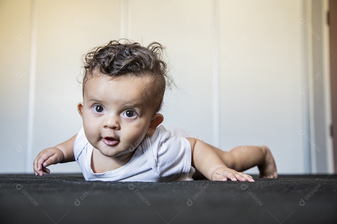 Um bebê fofo deitado na cama