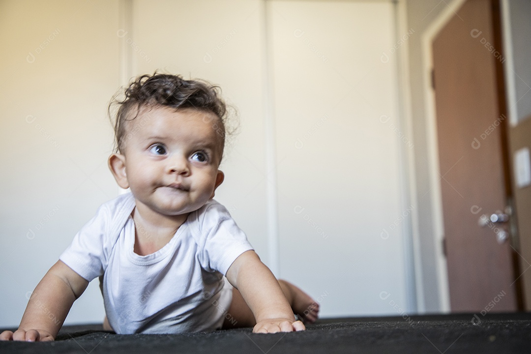 Um bebê fofo deitado na cama