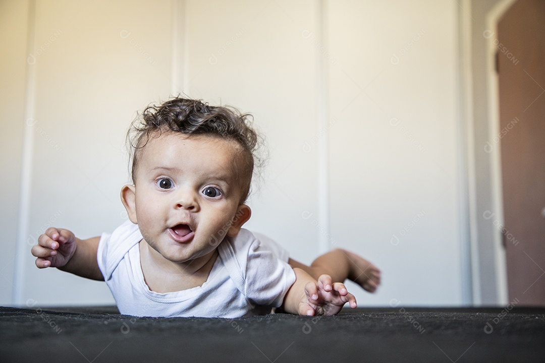 Bebê fofo deitado na cama brincando