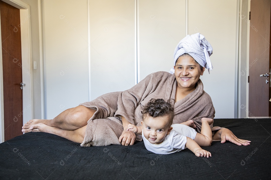 Uma mãe muito feliz com seu bebê na cama