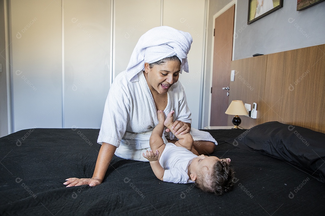 Mãe dedicada e carinhosa segurando seu bebê feliz