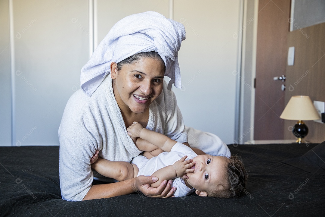 Mãe dedicada e carinhosa segurando seu bebê feliz