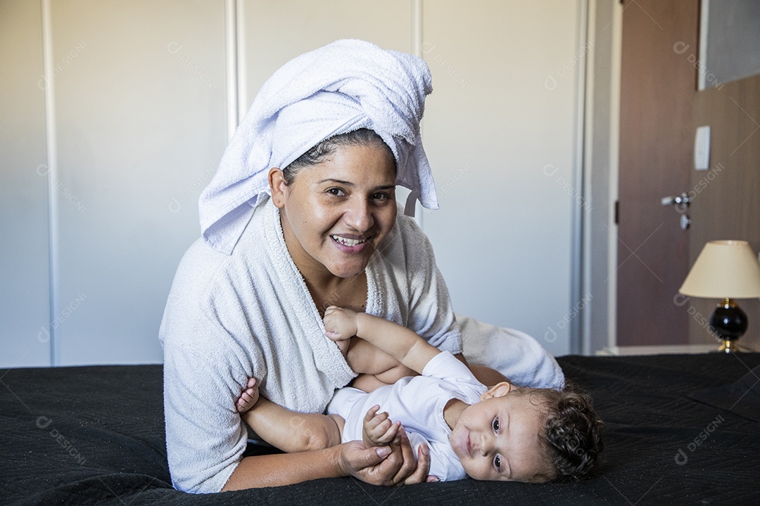 Mãe contente olhando e segurando seu bebê no colo
