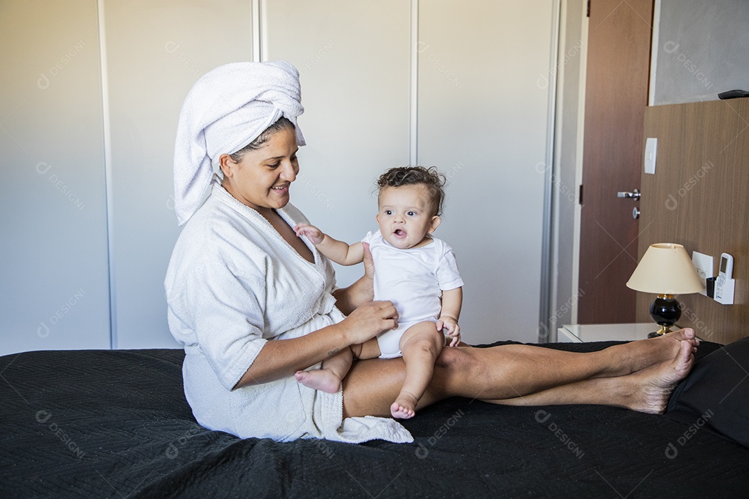 Mãe dedicada e carinhosa segurando seu bebê feliz