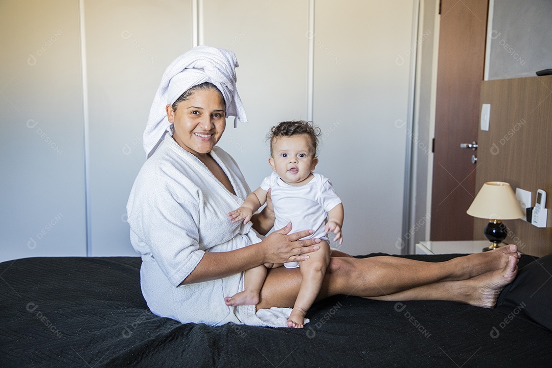 Mãe feliz com seu bebê no colo depois do banho