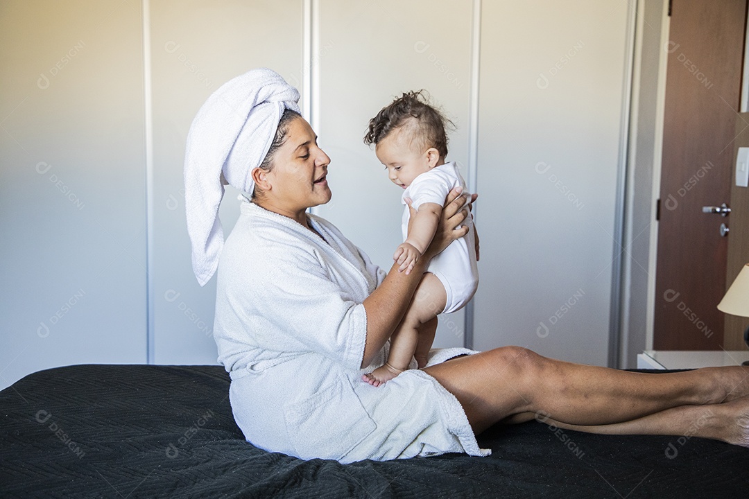 Mãe dedicada e carinhosa segurando seu bebê feliz