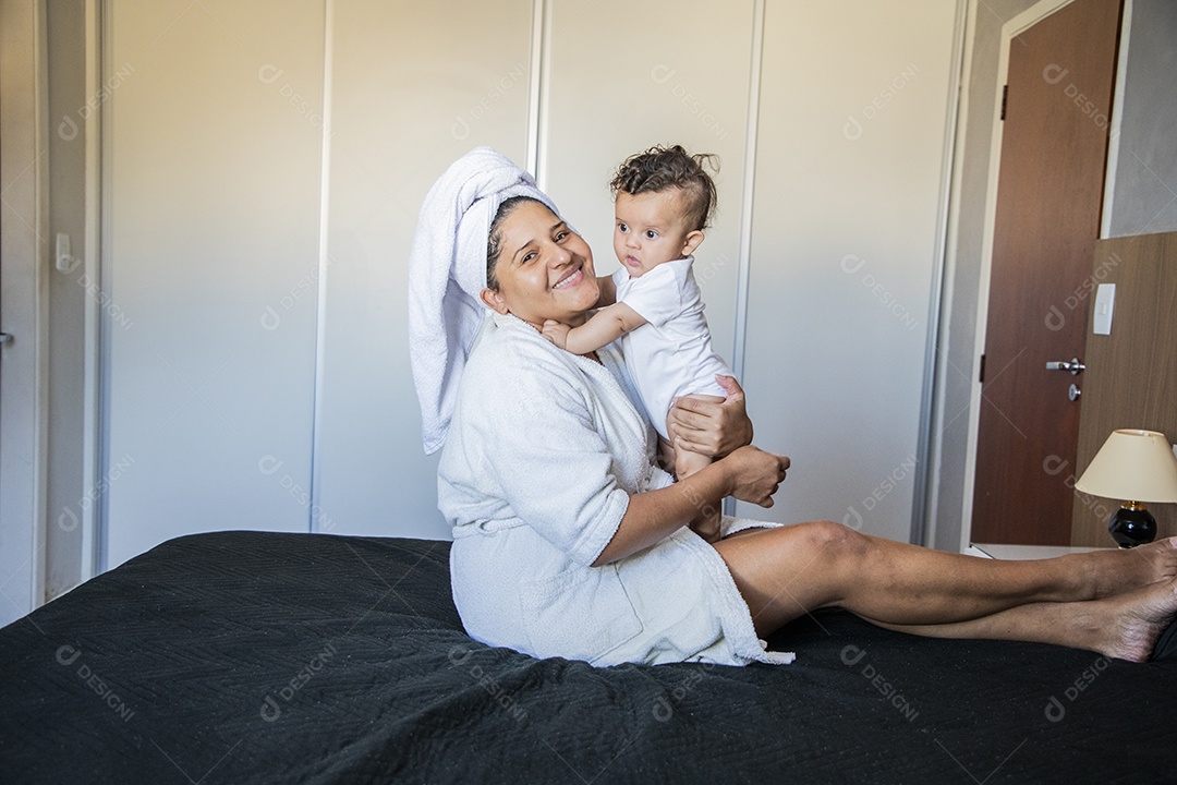 Mãe segurando seu bebê no colo muito felizes