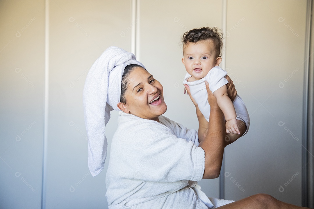 Mãe segurando seu bebê no colo muito felizes