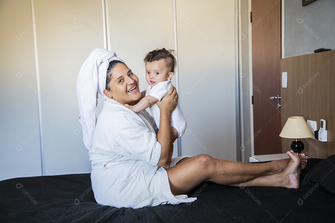 Mãe dedicada e carinhosa segurando seu bebê feliz