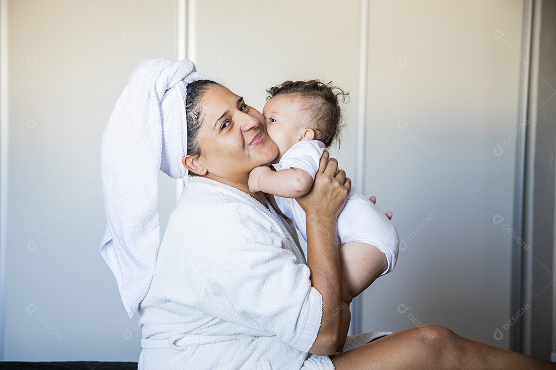 Mãe sendo agarrada por seu bebê com muito amor