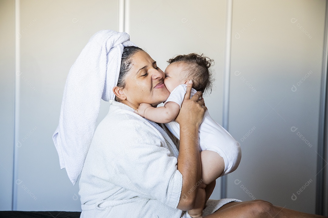 Mãe sendo agarrada por seu bebê com muito amor