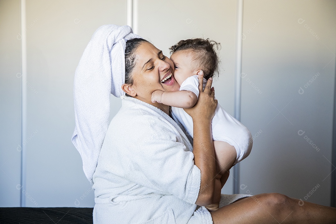 Mãe sendo agarrada por seu bebê com muito amor