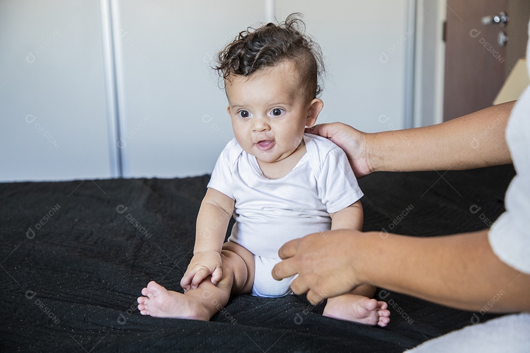 Bebê fofo sentando na cama