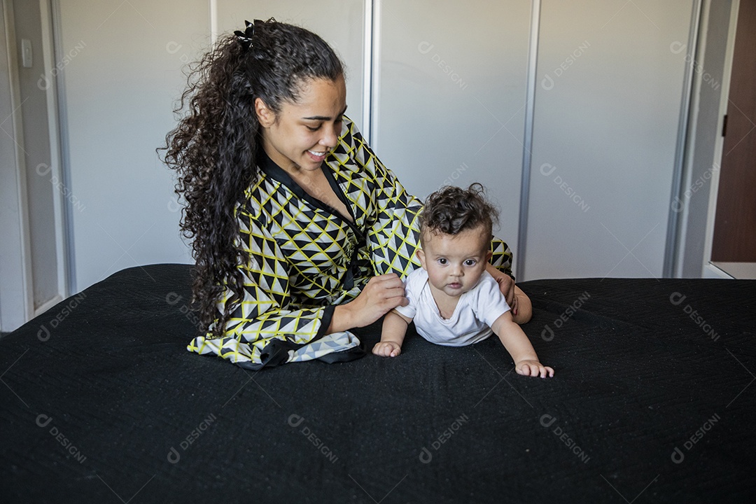 Mãe deitada na cama com seu bebê