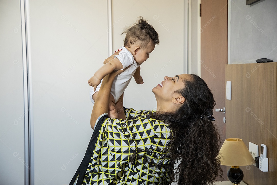 Mãe dedicada e carinhosa segurando seu bebê feliz