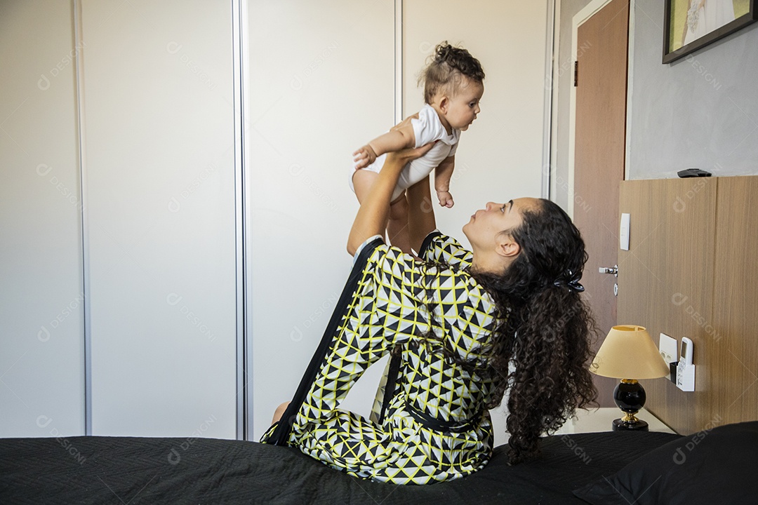 Mãe dedicada e carinhosa segurando seu bebê feliz