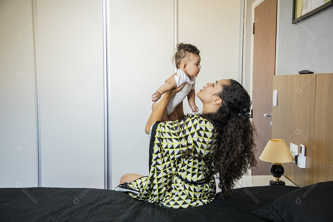 Mãe dedicada e carinhosa segurando seu bebê feliz