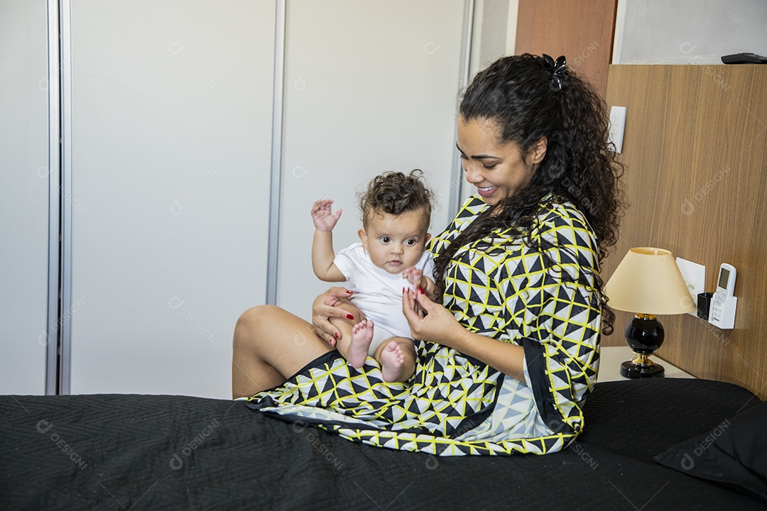 Mãe dedicada e carinhosa segurando seu bebê feliz