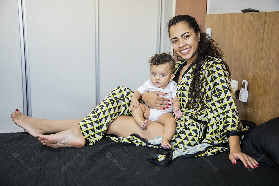 Mãe com seu bebê deitados na cama