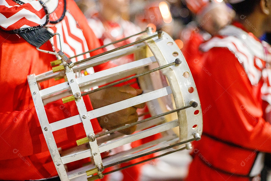 Homem tocando cuíca durante desfile de escola de samba