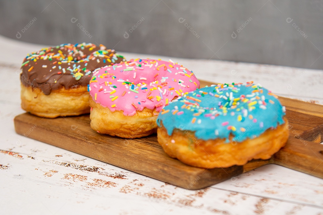 Tábua de madeira donuts rosa azul e chocolate com granulados