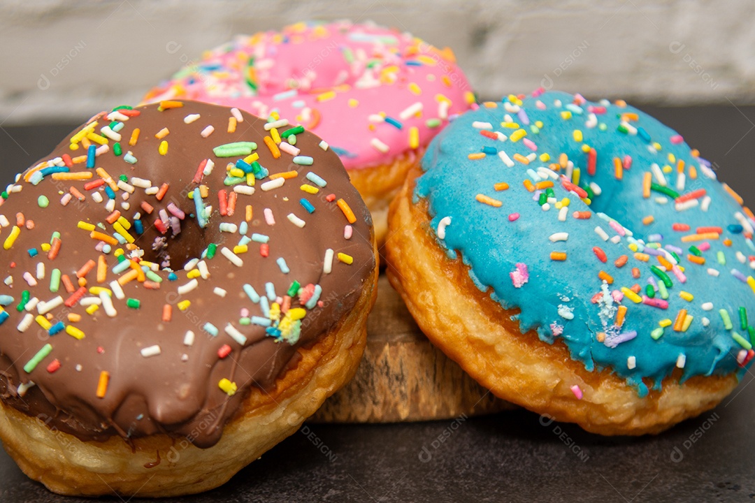 Três donuts delicioso sobre tábua