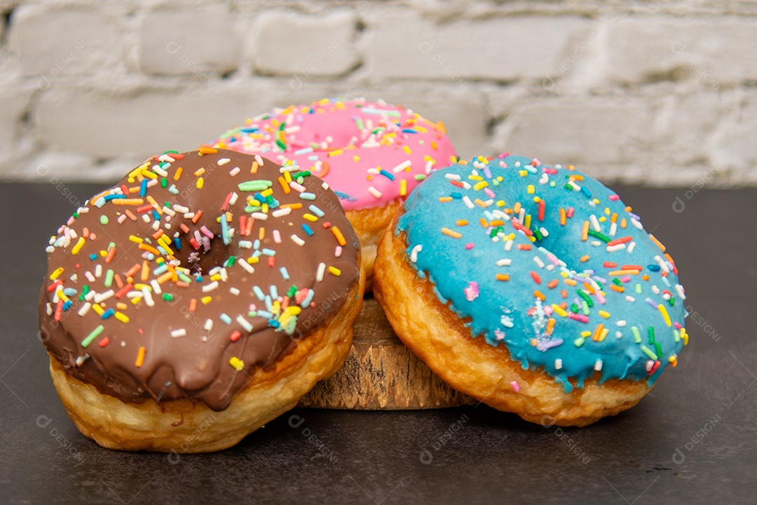 Três donuts delicioso sobre tábua